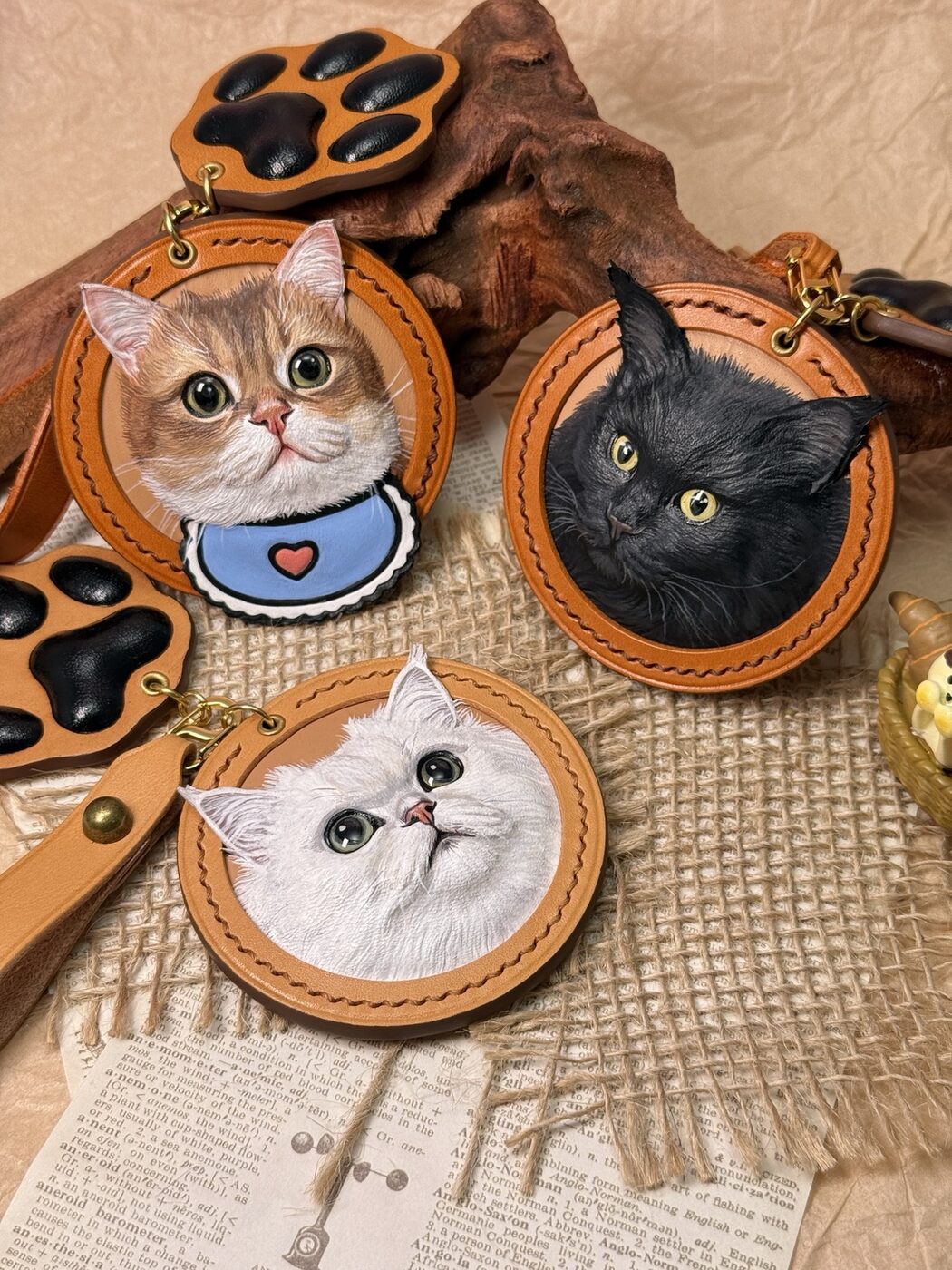 Three individually carved leather cat portraits