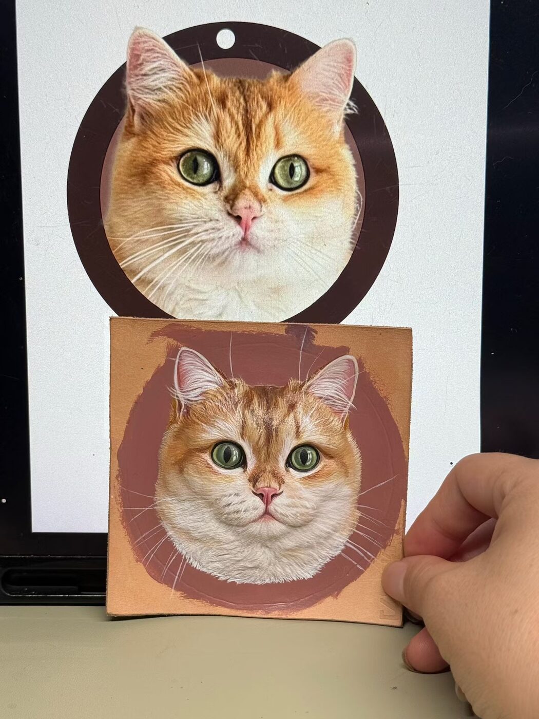Ginger cat reference photo beside its hand-painted leather portrait