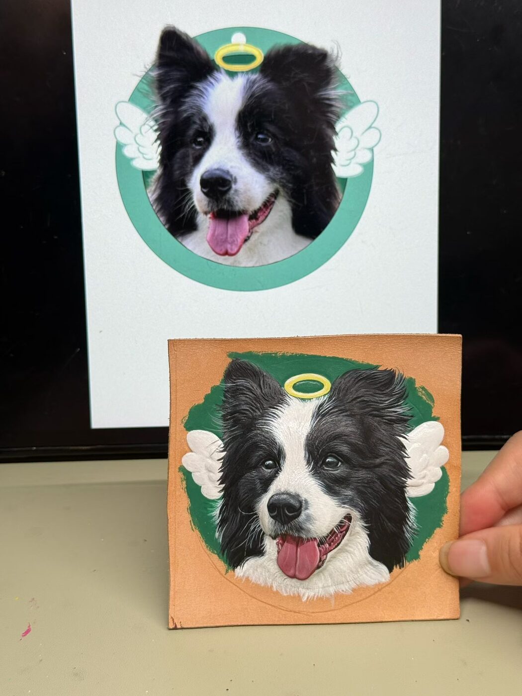 Black and white dog reference with halo and wings beside its memorial leather portrait