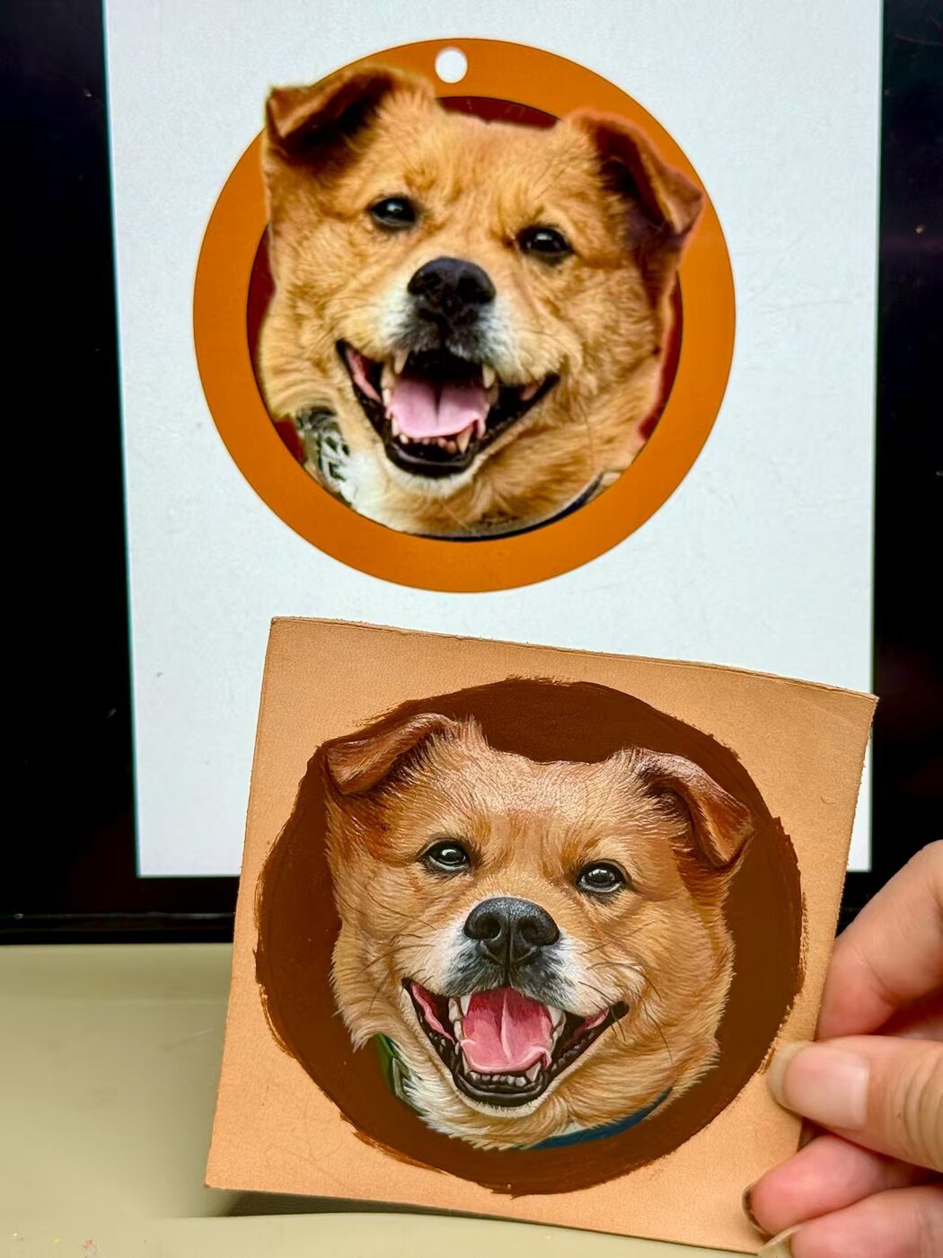 Smiling dog reference photo beside its hand-painted leather portrait
